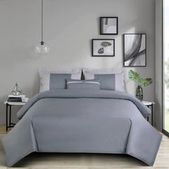 Gray bedding set on a bed in a bedroom with abstract art on the wall.