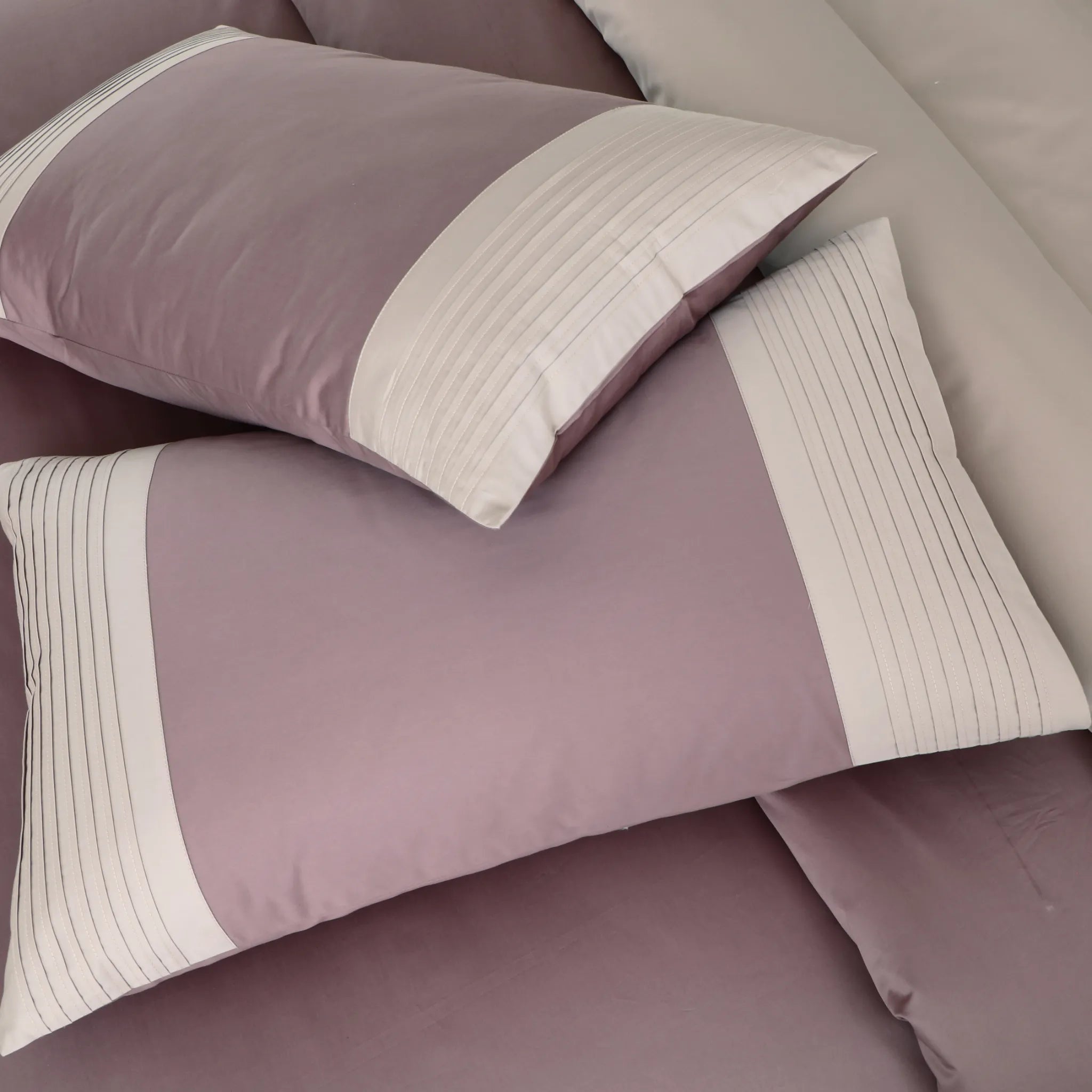 Close-up of wine bed sheets with matching pillows.