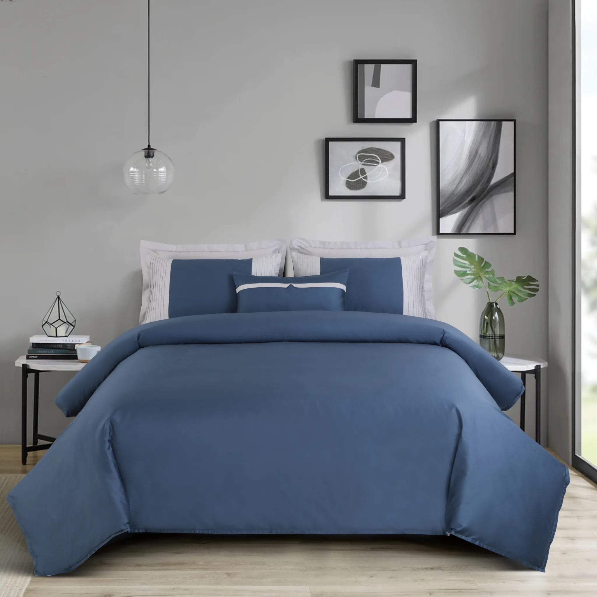 Blue bedding set on a bed in a modern bedroom with abstract art on the wall.