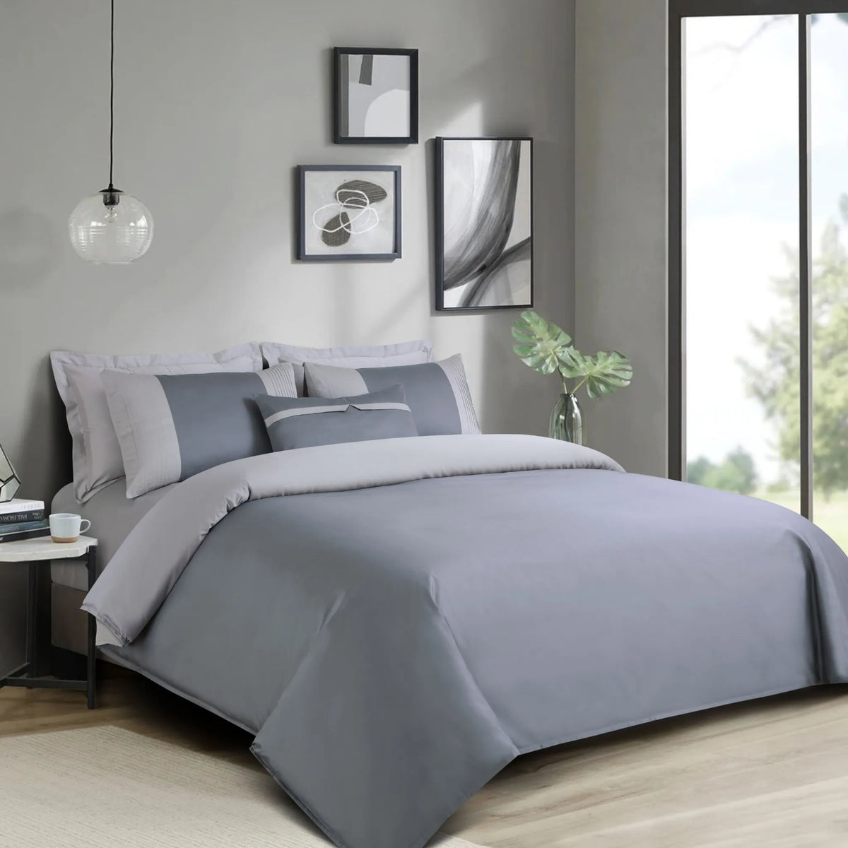Gray bedding set on a bed in a modern bedroom with decor elements.