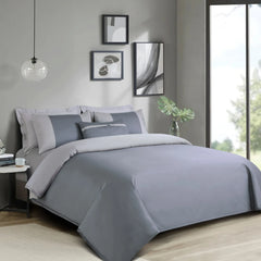 Gray bedding set on a bed in a modern bedroom with decor elements.