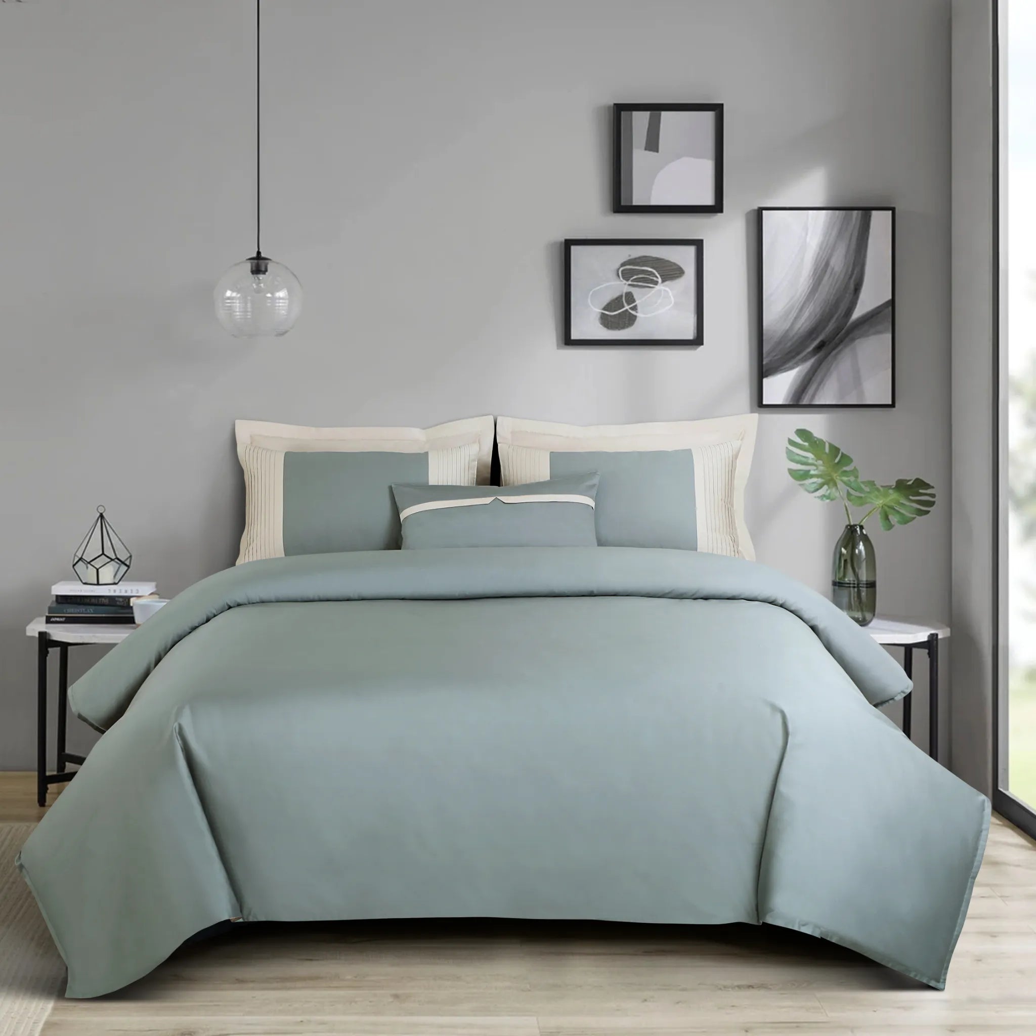 Bedroom with a bed covered in olive green bedding, nightstands, and wall art.