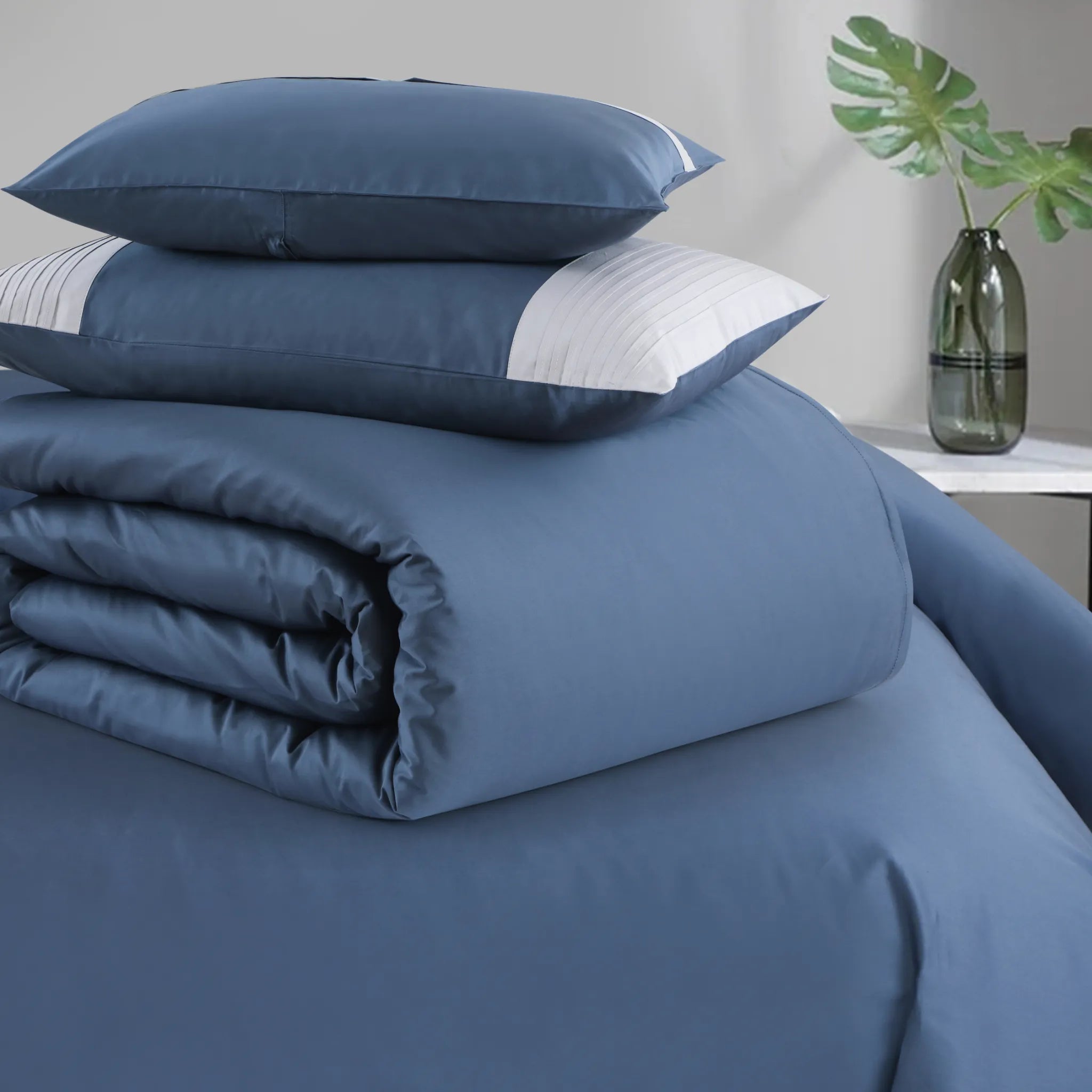 Blue bedding set with pillows on a bed in a room setting.